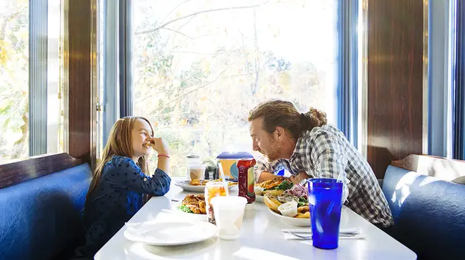 Girl and father laughing over dinner