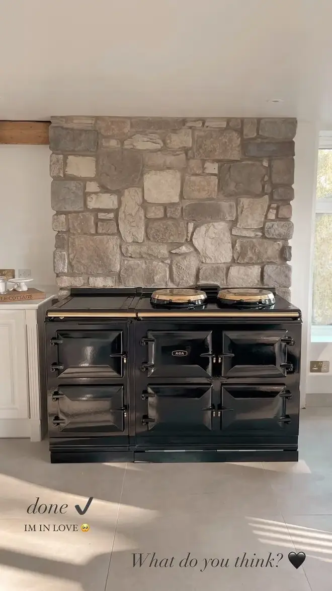 Stacey Solomon's kitchen has a beautiful stone wall which they have placed a black and gold AGA in front of