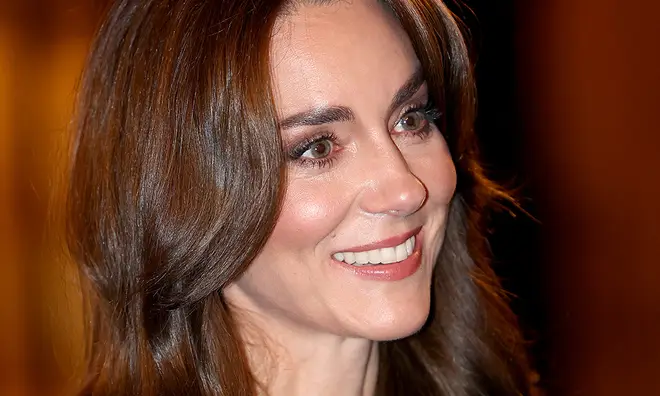 Kate Middleton smiling with her brown hair down and shiny