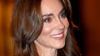 Kate Middleton smiling with her brown hair down and shiny