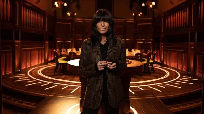 Claudia Winkleman standing in front of the round table on The Traitors
