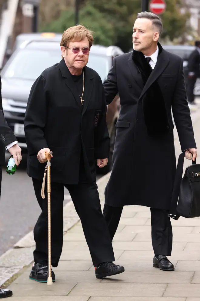Elton John and his husband David Furnish arrive at the funeral of Derek Draper