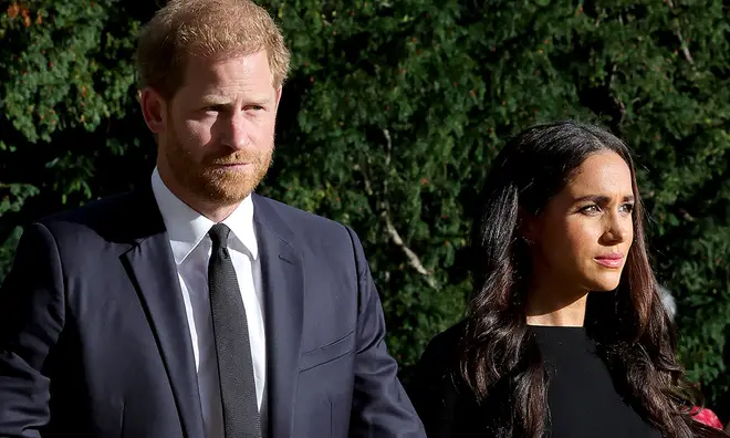 Prince Harry and Meghan Markle looking somber in black