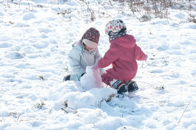 Two children play in the snow