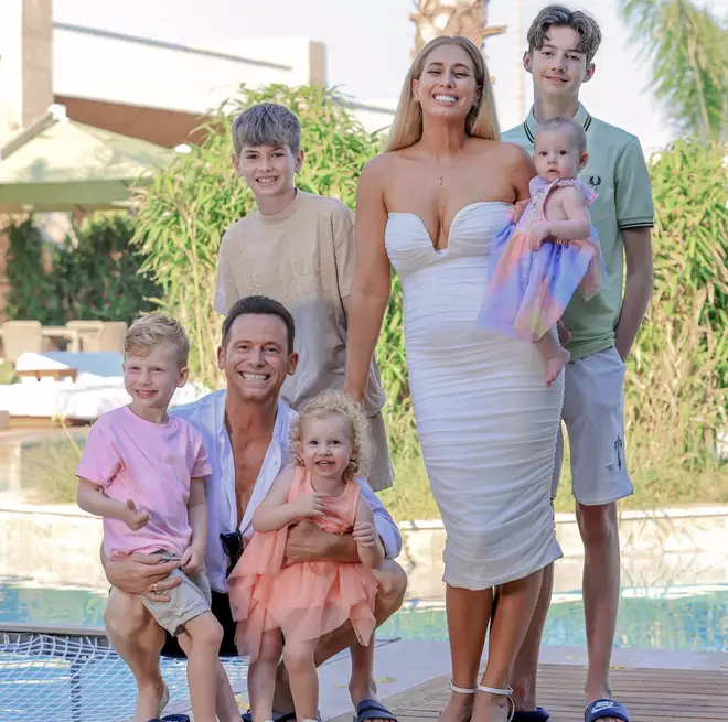 Stacey Solomon smiles with Joe Swash and their children