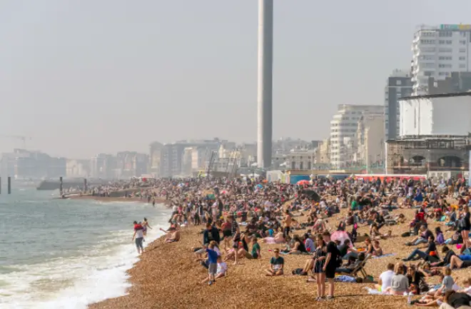 A packed Brighton beach in the sunshine