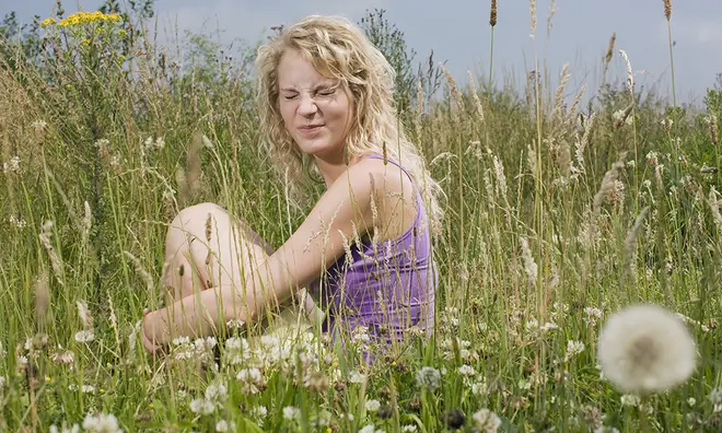 Woman scrunching up nose in a field