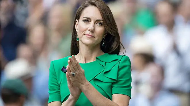 Kate Middleton wearing a green suit and clapping