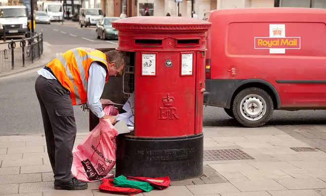 Royal Mail worker collecting letters from post box
