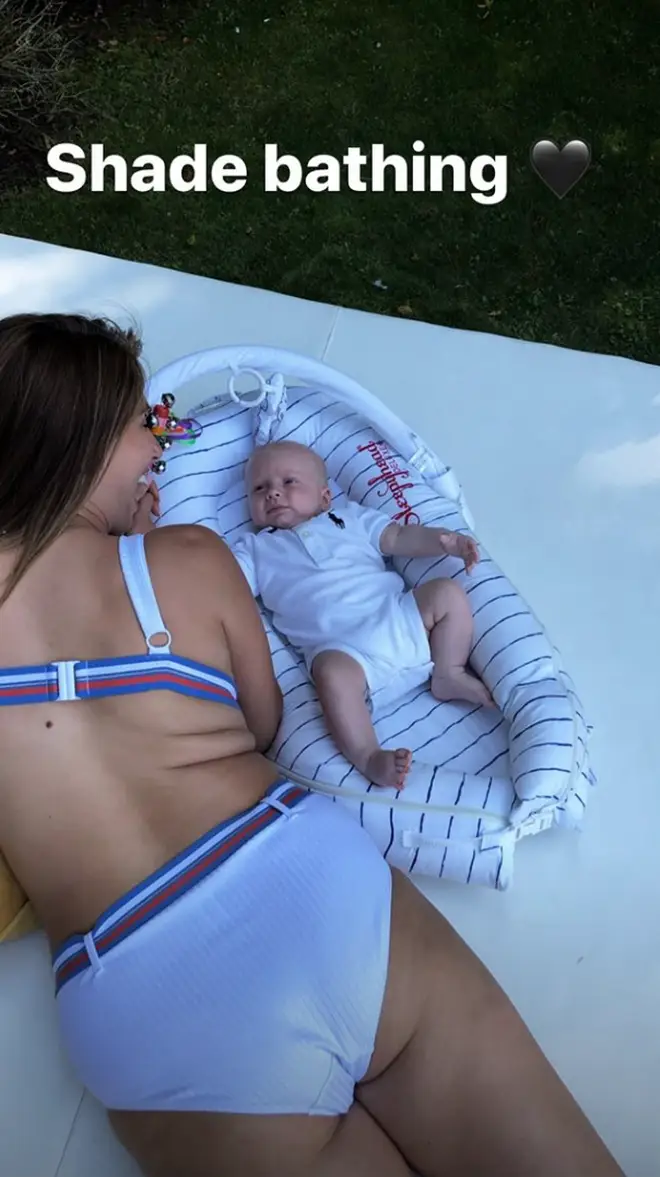The 29-year-old stunned as she relaxed in the shade with three-month-old baby Rex.