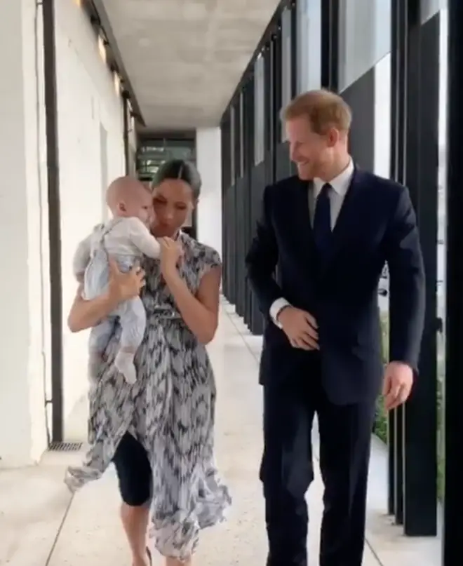 The Duchess held baby Archie close as they walked to meet the Archbishop