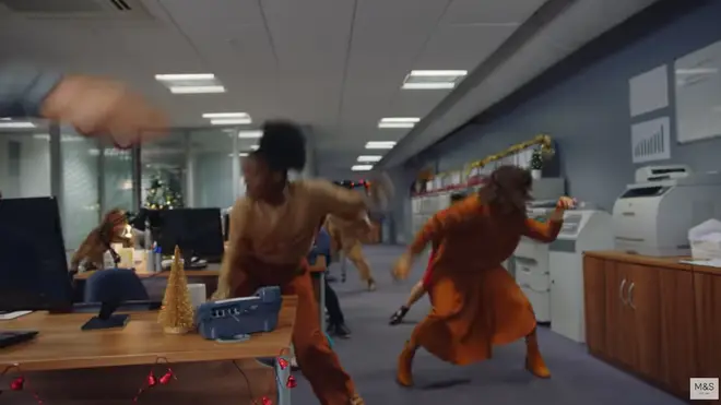 The ad features office workers dancing in various M&S jumpers